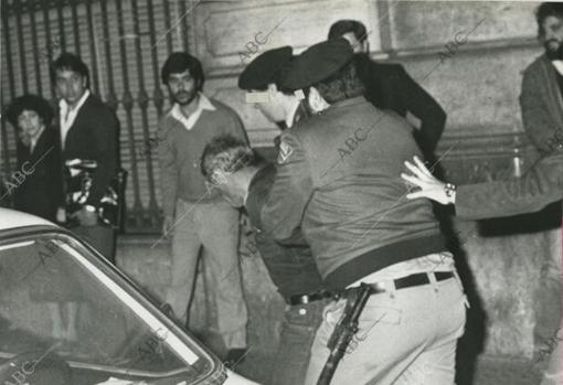 Uno de los atracadores detenidos es conducido por policías nacionales